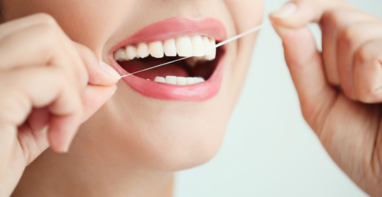 Zähne werden gereinigt mit Zahnseide
